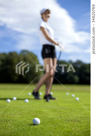 Pretty girl playing golf on grass 34820769