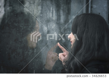 Woman and her reflection on rainy window Woman and her reflection on rainy window 34826653