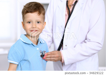 Happy little boy having fun while is being examine Happy little boy having fun while is being examine 34829122