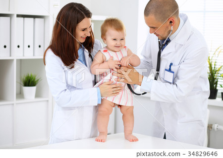 Happy cute baby at health exam at doctor's offic Happy cute baby at health exam at doctor's offic 34829646