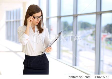 Modern business woman standing  and keeping paper 34829748