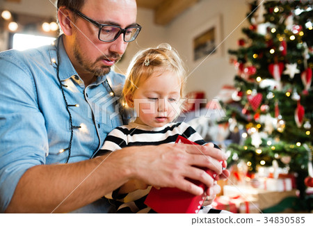 Little girl with her father opening Christmas 34830585