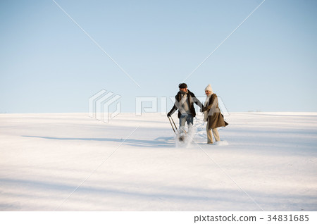 Beautiful senior couple on a walk pulling sledge 34831685