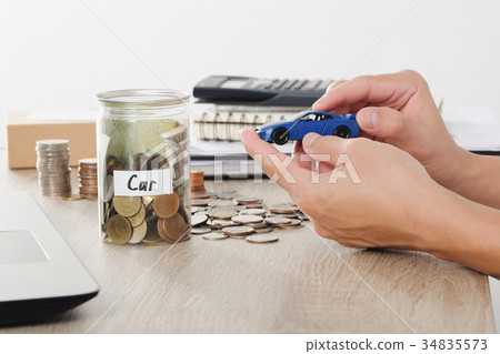 Man hand holding car toy on coin stack for Man hand holding car toy on coin stack for 34835573