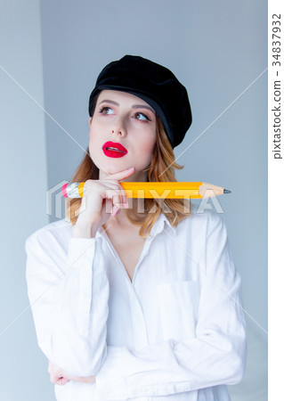 Young redhead woman in hat holding chuge pencil 34837932