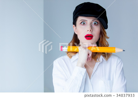 Young redhead woman in hat holding chuge pencil 34837933