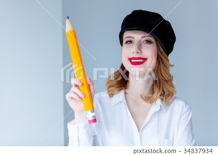 Young redhead woman in hat holding chuge pencil 34837934