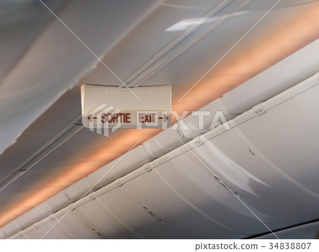 emergency exit sign on the ceiling of airplane emergency exit sign on the ceiling of airplane 34838807