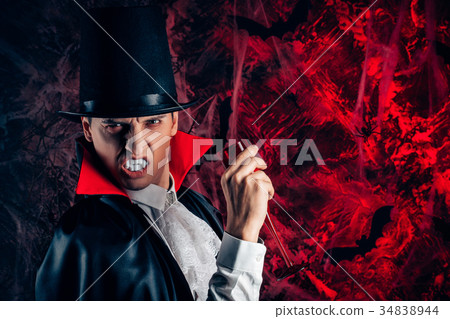 handsome man dressed in a Dracula costume for 34838944