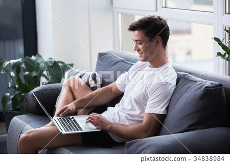 Joyful pleasant guy is using modern device Joyful pleasant guy is using modern device 34838984