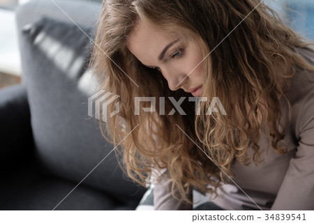 Depressed female sitting on cozy sofa Depressed female sitting on cozy sofa 34839541