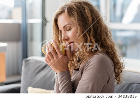 Glad woman drinking cup of beverage Glad woman drinking cup of beverage 34839819