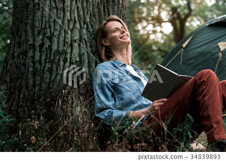 Happy woman reading literature in nature 34839893