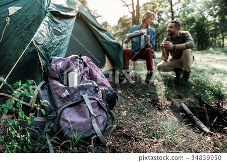 Cheerful man and woman enjoying beverage in forest 34839950
