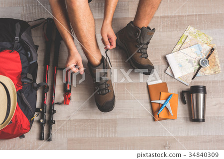 Man lacing up his boots for amping trip 34840309