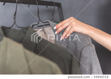 Woman going to take rack with coat Woman going to take rack with coat 34840319