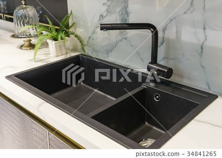 Black kitchen sink and Tap water in the kitchen. Black kitchen sink and Tap water in the kitchen. 34841265