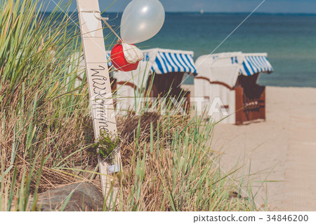 Blue colored roofed chairs on sandy beach in 34846200