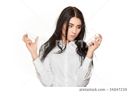 Unhealthy girl choosing nasal spray for flue or Unhealthy girl choosing nasal spray for flue or 34847239