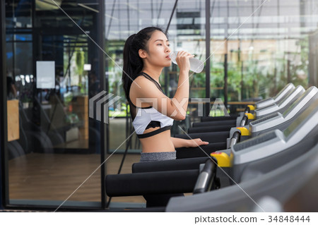 Fitness woman drinking water from bottle after run 34848444
