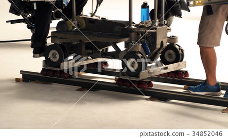 Production crew setting dolly track in studio. Production crew setting dolly track in studio. 34852046