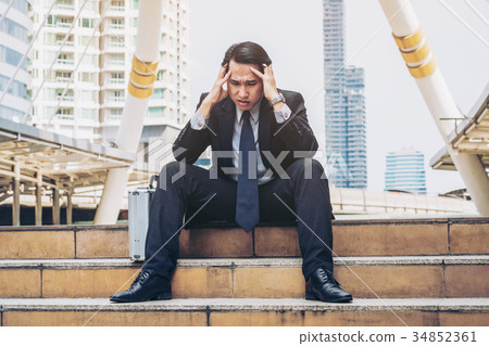 Desperate businessman sitting hopelessly on stair floor 34852361