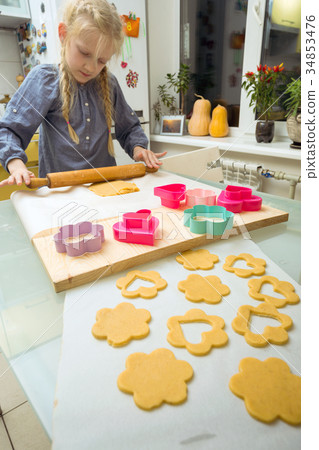 little girl makes a cookie in the kitchen 34853476