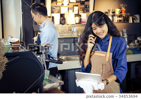 Asian barista talking order by phone Asian barista talking order by phone 34853694
