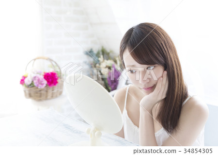 Beauty young woman looking at mirror check acne rough skin 34854305