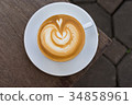 A white cup of coffee latte art on wood table 34858961