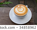 A white cup of coffee latte art on wood table 34858962