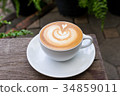 A white cup of coffee latte art on wood table 34859011