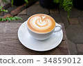 A white cup of coffee latte art on wood table 34859012