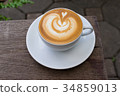 A white cup of coffee latte art on wood table 34859013