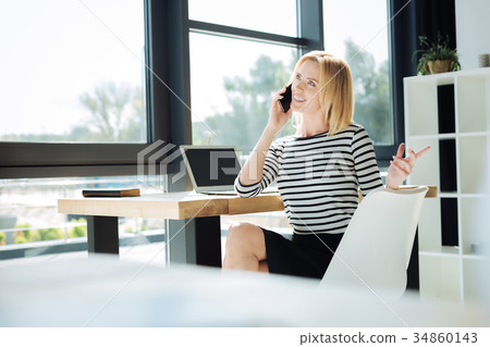 Attractive confident businesswoman talking on the 34860143