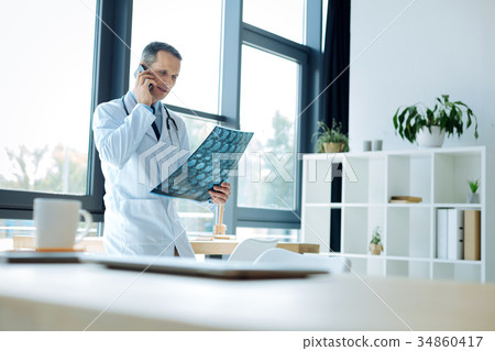 Pleasant intelligent doctor making a call Pleasant intelligent doctor making a call 34860417