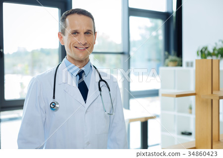 Positive nice man standing in his office 34860423