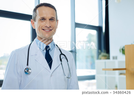 Positive delighted doctor smiling to you Positive delighted doctor smiling to you 34860426