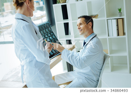 Joyful professional neurologists discussing an Joyful professional neurologists discussing an 34860493