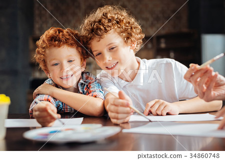 Loving brothers painting together at table Loving brothers painting together at table 34860748
