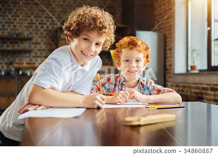 Cheerful boys grinning broadly for camera while 34860887