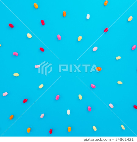 Round frame made of colored candies on blue Round frame made of colored candies on blue 34861421