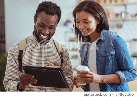 Upbeat friends checking cafe menu on tablet 34862100