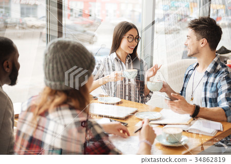 Optimistic friends drinking tea in the restaurant Optimistic friends drinking tea in the restaurant 34862819