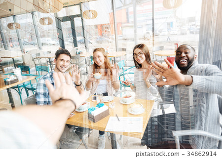 Pleased friends giving five at the table 34862914