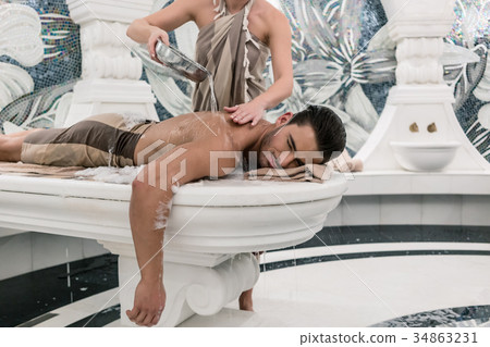 Relaxed man lying down on hot marble bed during Relaxed man lying down on hot marble bed during 34863231