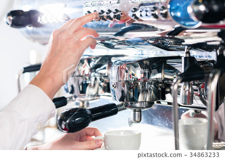 Close-up of female hand on the portafilter of an 34863233