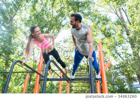 Young fit woman and her partner practicing plank 34863260