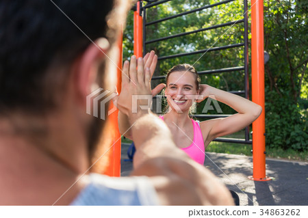 Cheerful young woman giving high-five to her Cheerful young woman giving high-five to her 34863262