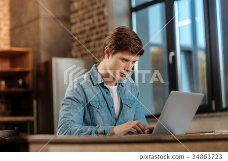 Young man developing a project on his laptop 34863723